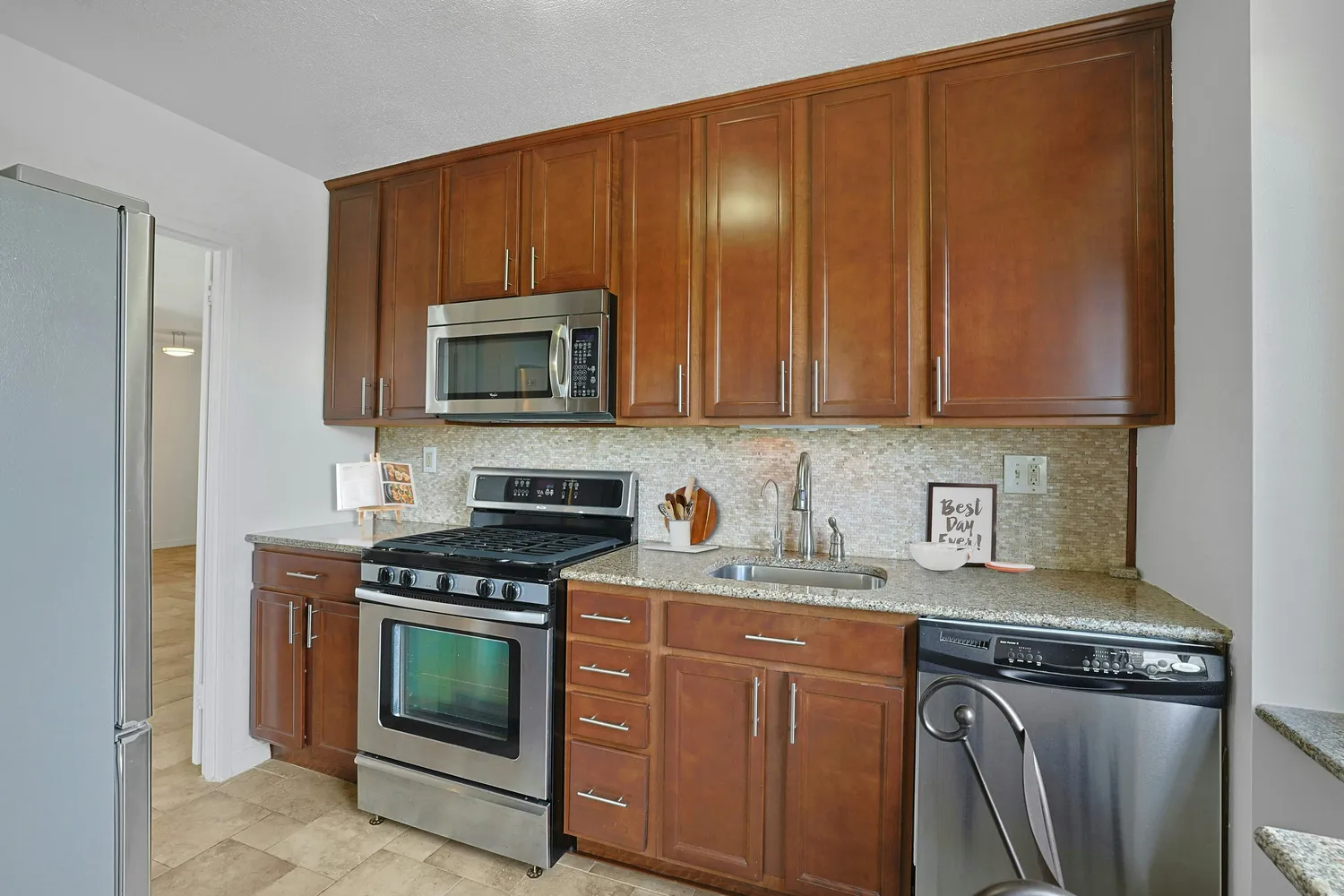 a kitchen with granite countertop wooden cabinets and stainless steel appliances