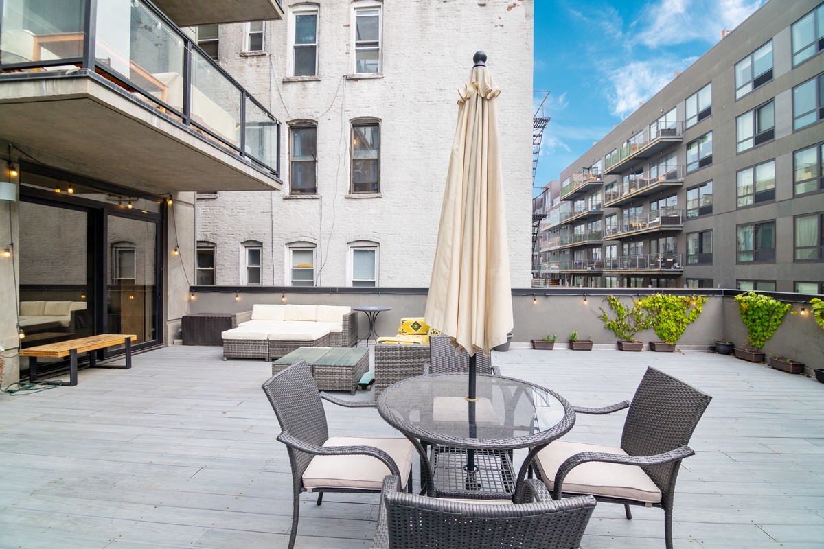 11-12 44th Drive, Unit 2B Queens, NY 11101 - Photo 2 of 15 a view of a patio with couches table and chairs and potted plants