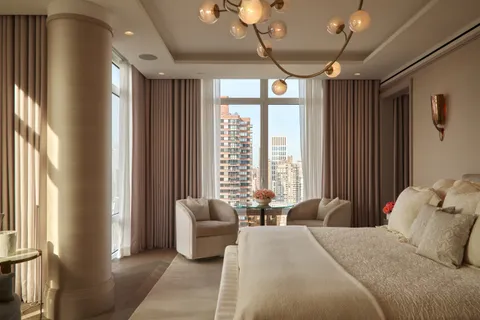 a bedroom with a large bed and a chandelier