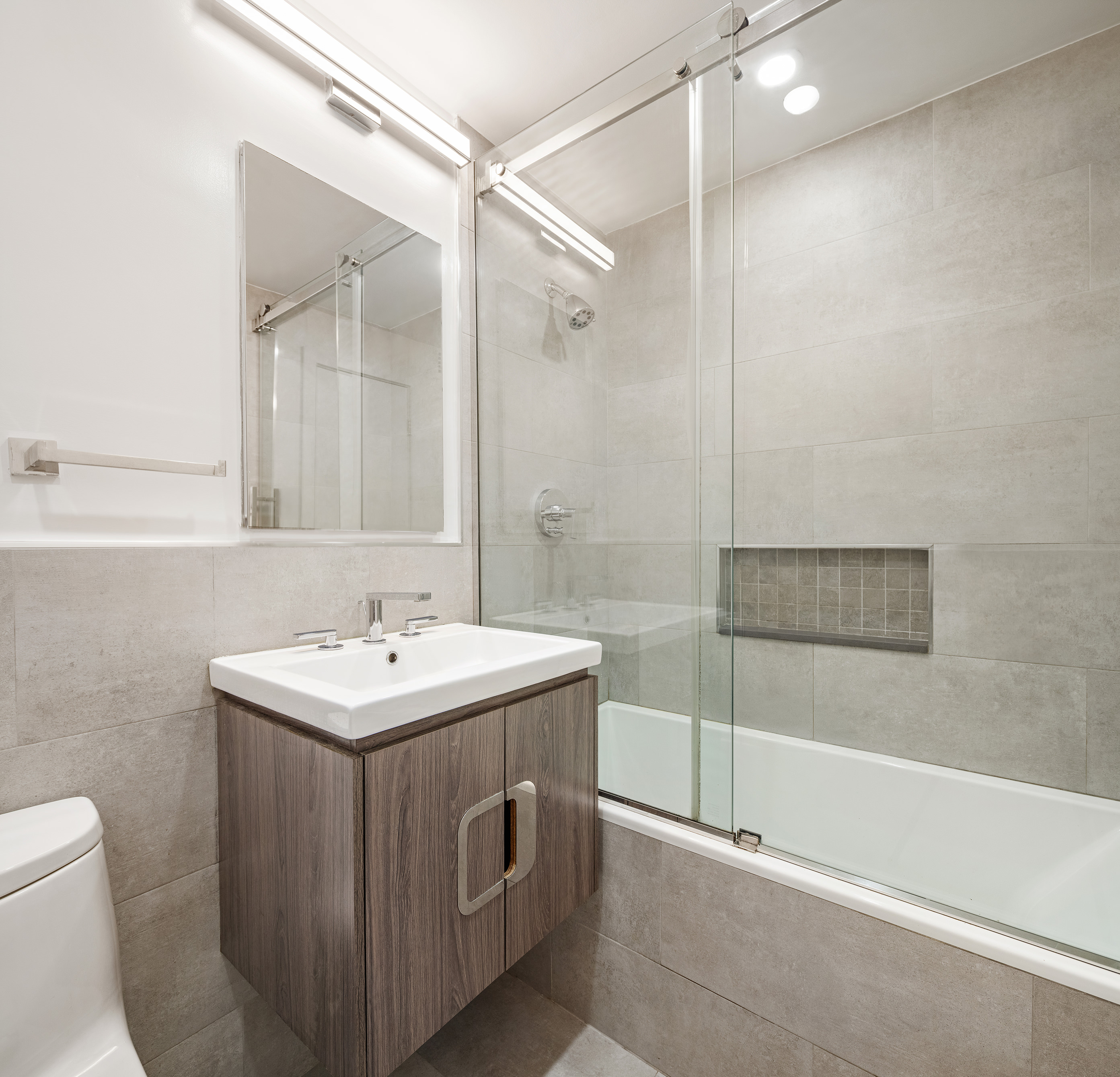 77 7th Avenue, Unit 12P Manhattan, NY 10011 - Photo 12 of 15 a bathroom with a sink toilet and shower
