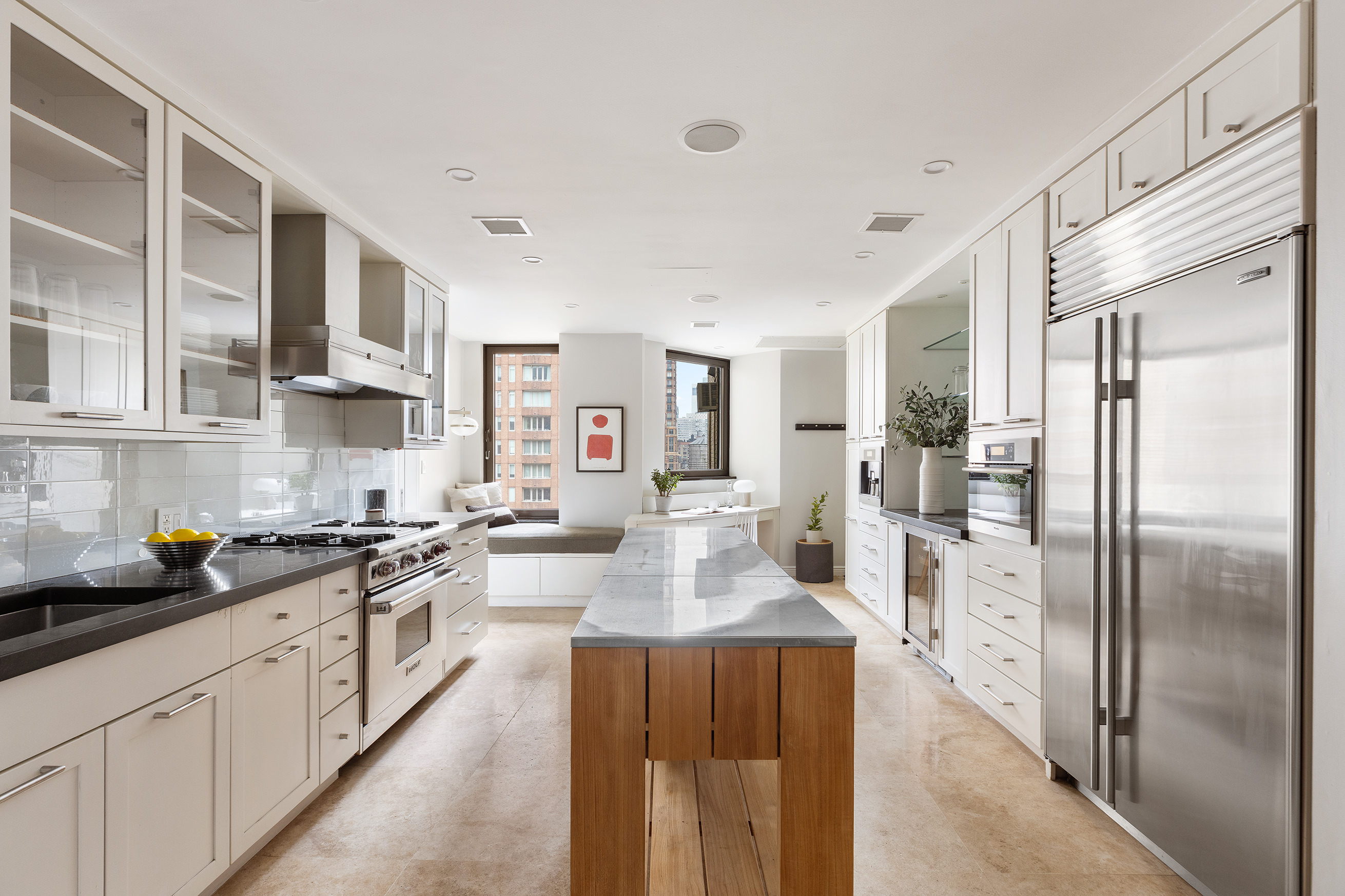 180 East 79th Street, Unit 14G Manhattan, NY 10075 - Photo 2 of 12 a large kitchen with stainless steel appliances granite countertop a lot of counter space and a refrigerator