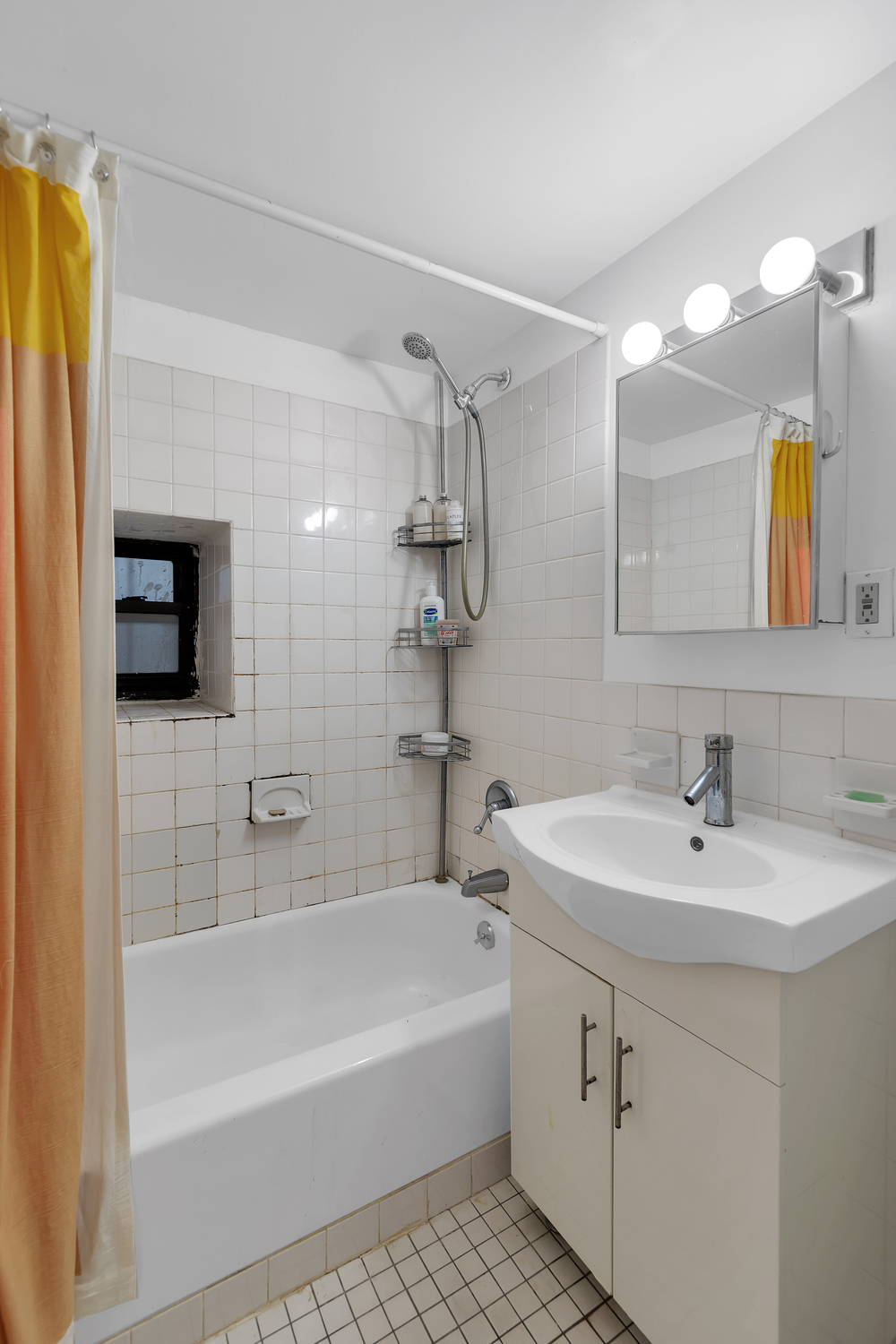 224 East 11th Street, Unit GARDEN Manhattan, NY 10003 - Photo 6 of 6 a bathroom with a sink a mirror and a bathtub