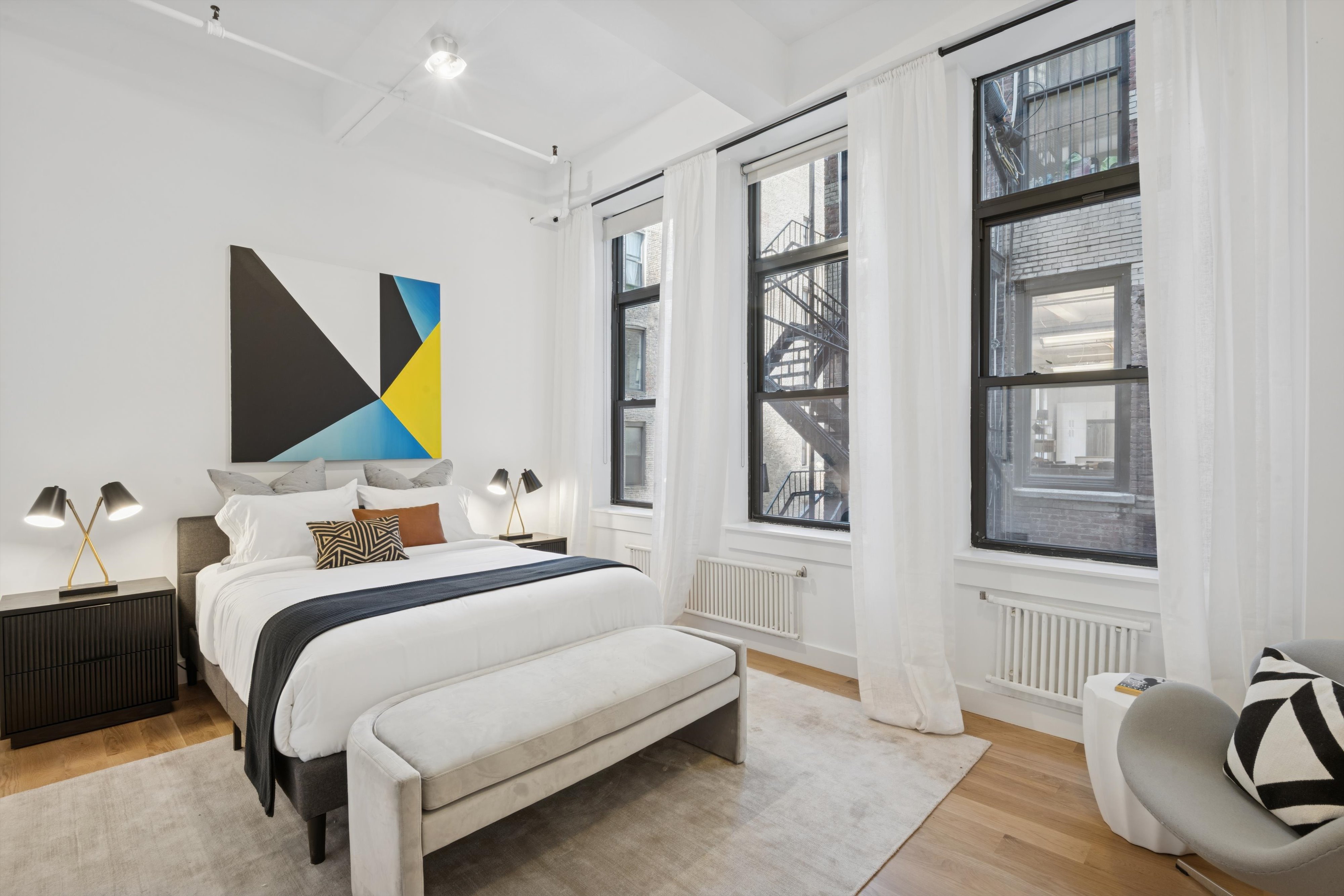 109 West 26th Street, Unit 9 Manhattan, NY 10001 - Photo 14 of 23 a bedroom with a bed and a painting on the wall