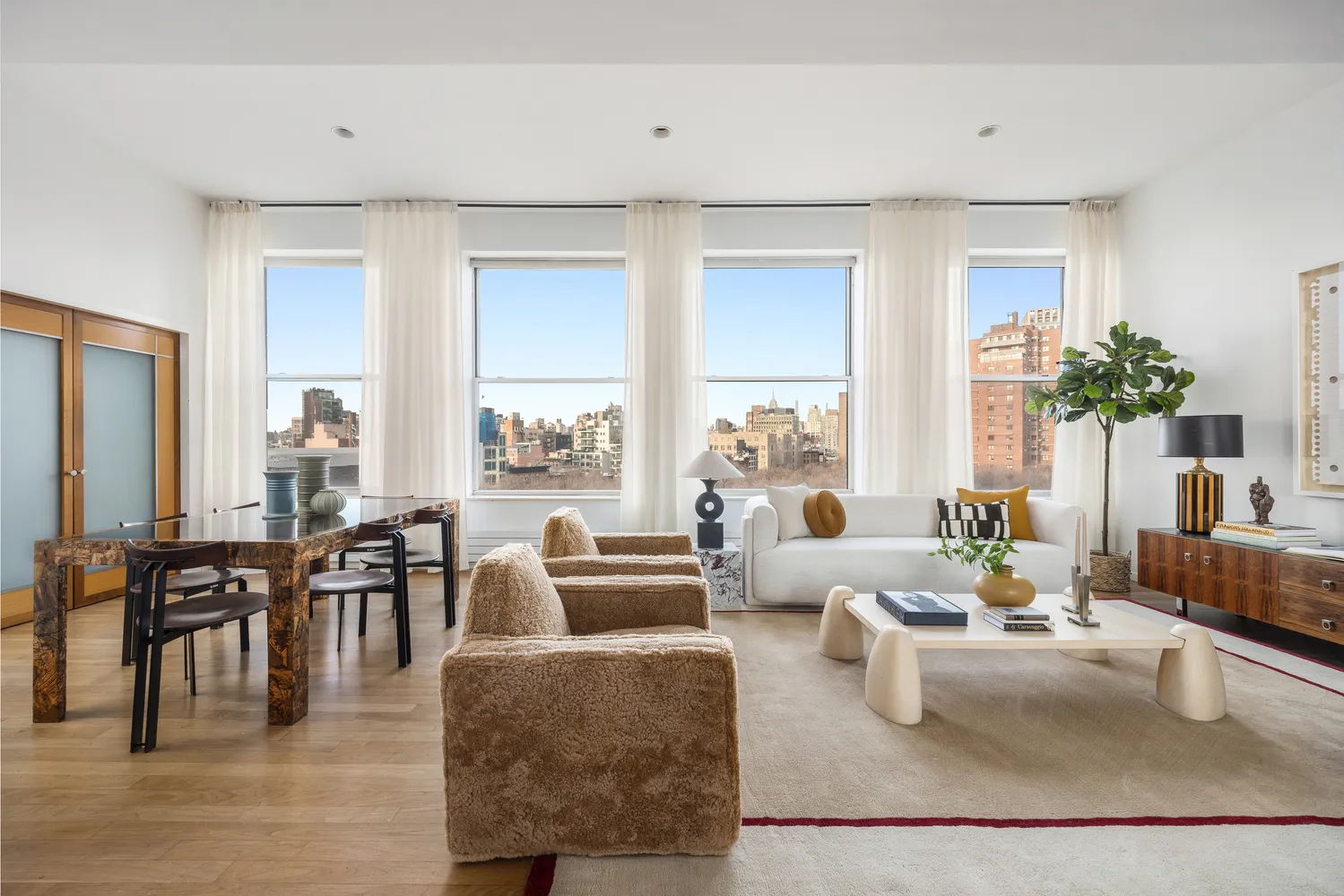 a living room with furniture potted plant and a large window