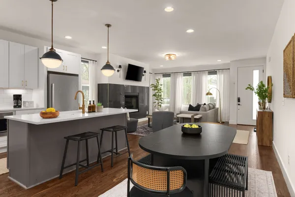 a kitchen with a table chairs sink and white cabinets