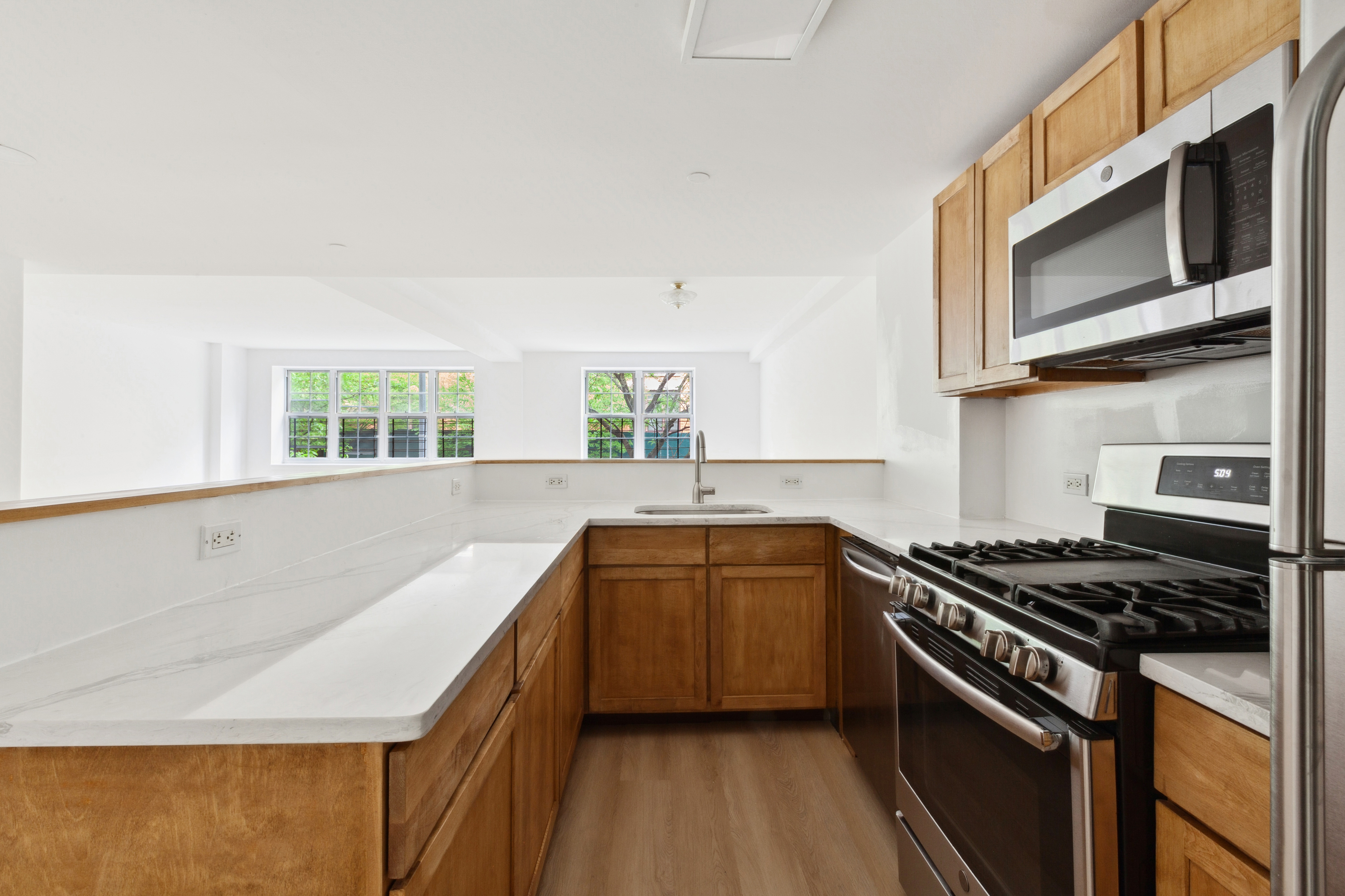 266 West 115th Street, Unit 2B Manhattan, NY 10026 - Photo 3 of 11 a kitchen with stainless steel appliances a sink stove and microwave