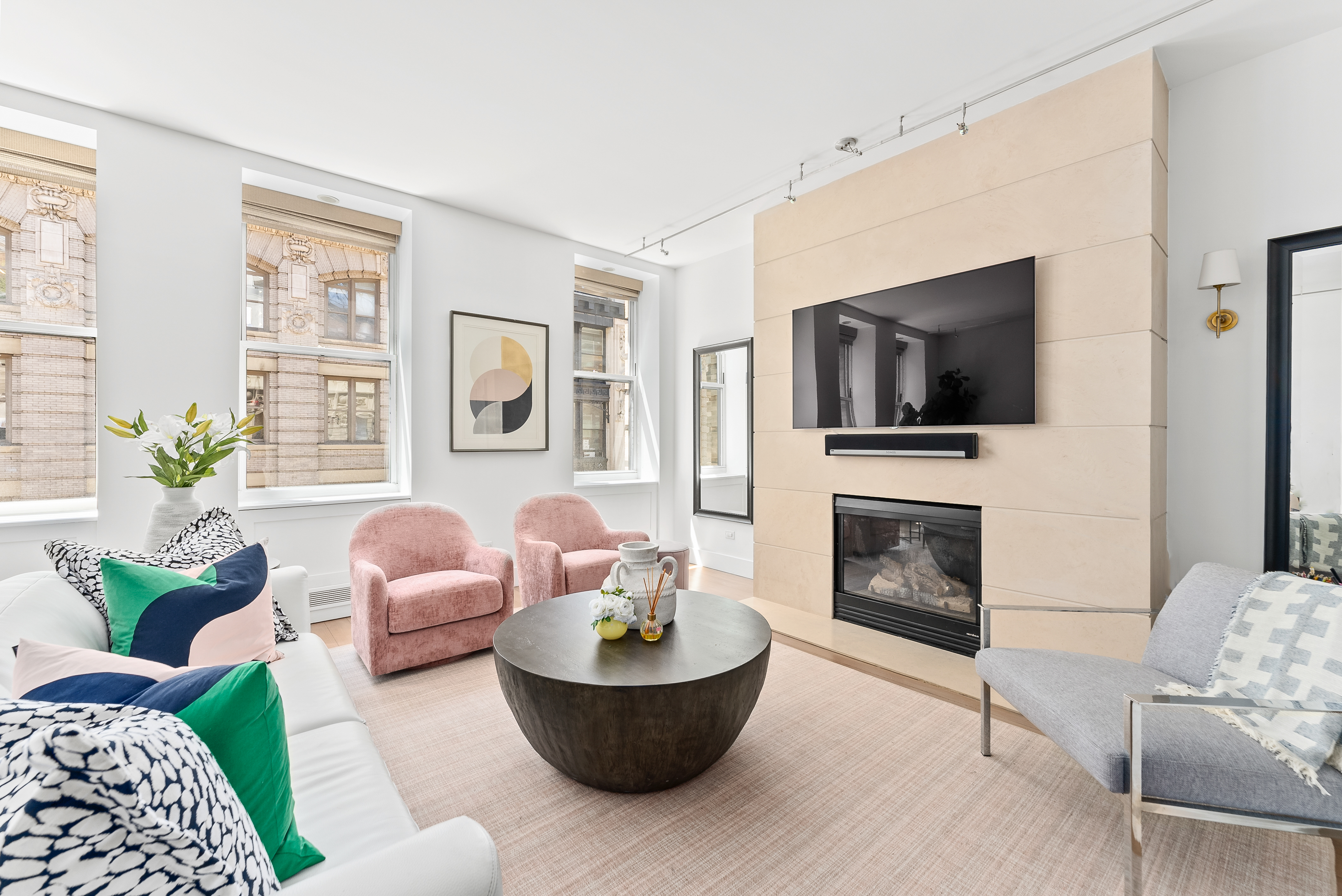 15 West 20th Street, Unit 9A Manhattan, NY 10011 - Photo 4 of 21 a living room with furniture a flat screen tv and a fireplace