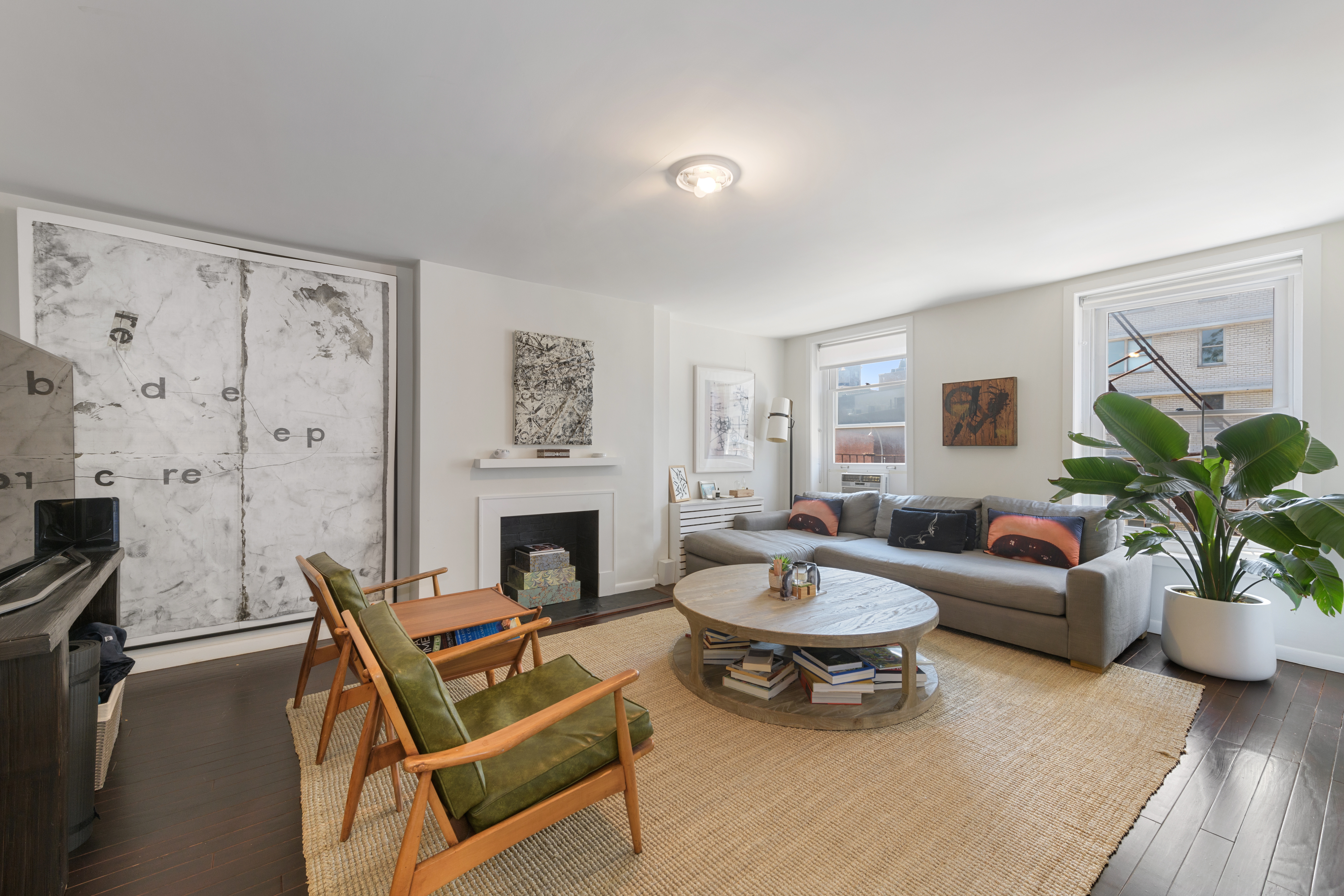 a living room with furniture a fireplace and a potted plant