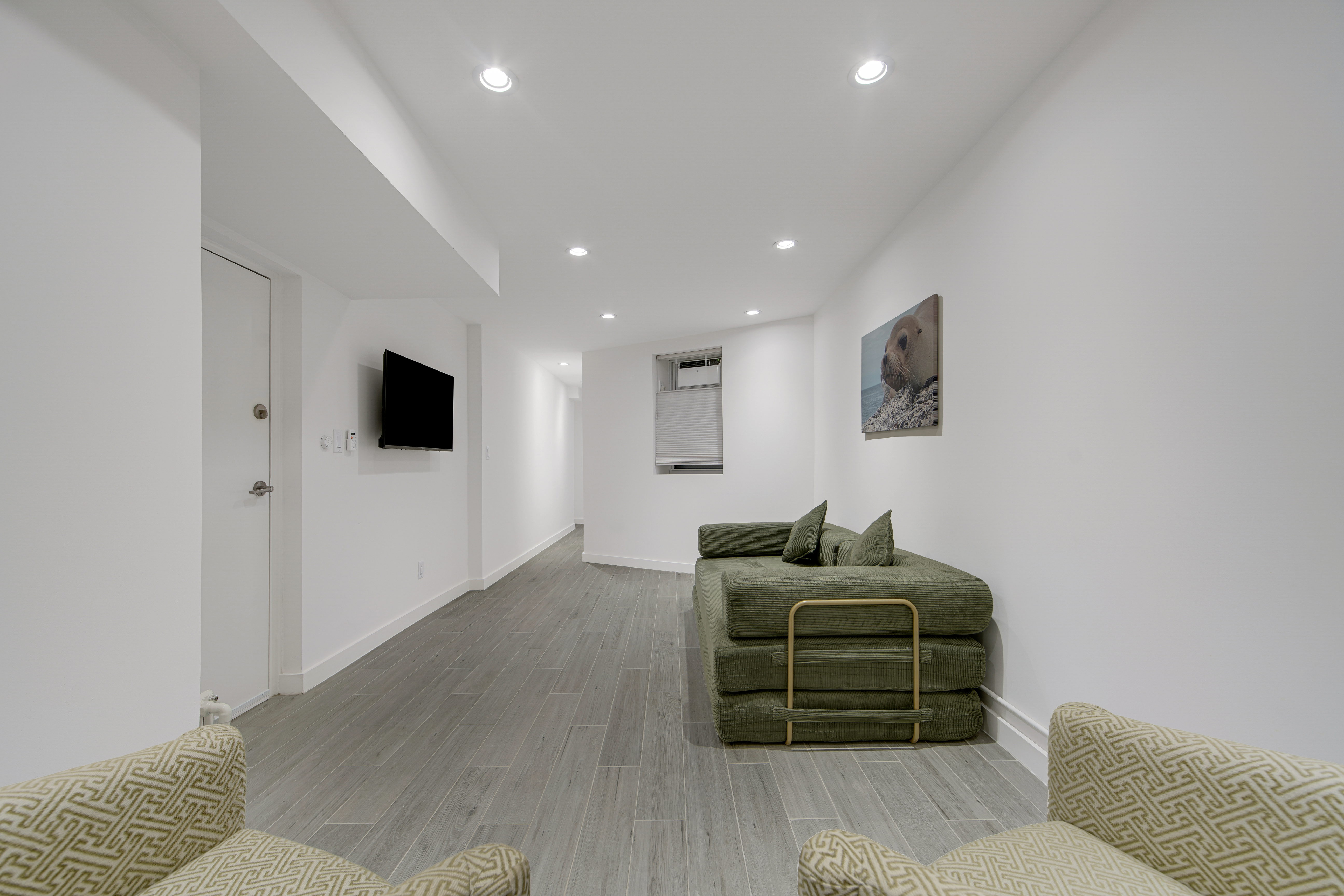 214 West 16th Street, Unit 1W Manhattan, NY 10011 - Photo 11 of 13 a living room with furniture and a flat screen tv