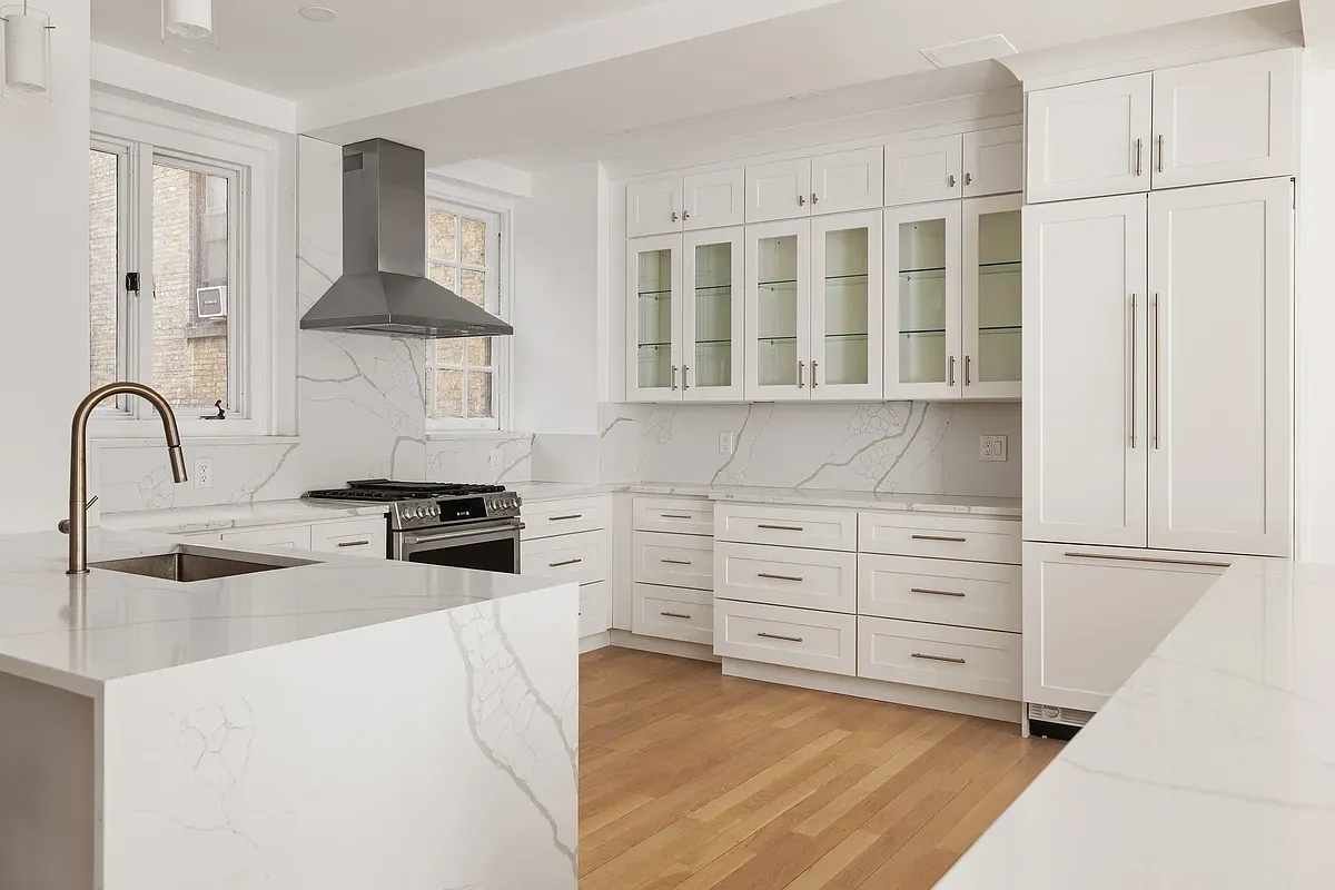 a kitchen with white cabinets and appliances