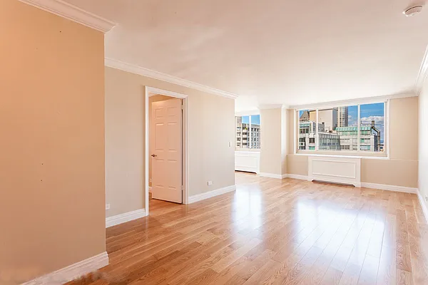 30 West 63rd Street, Unit 28L Manhattan, NY 10023 - Photo 4 of 11 an empty room with wooden floor and windows