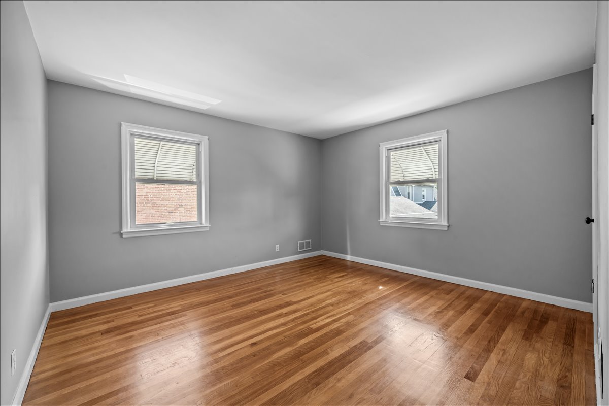 100-14 159th Avenue Queens, NY 11414 - Photo 13 of 26 a view of an empty room with wooden floor and a window