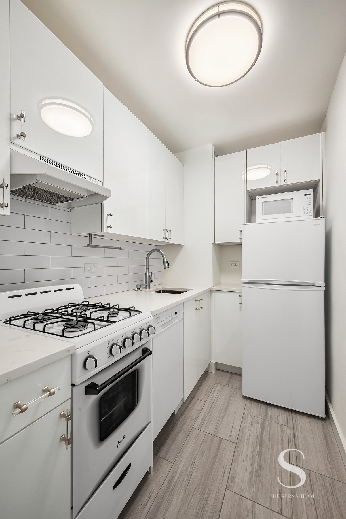 301 East 62nd Street, Unit 5E Manhattan, NY 10065 - Photo 3 of 15 a kitchen with a stove oven and white cabinets