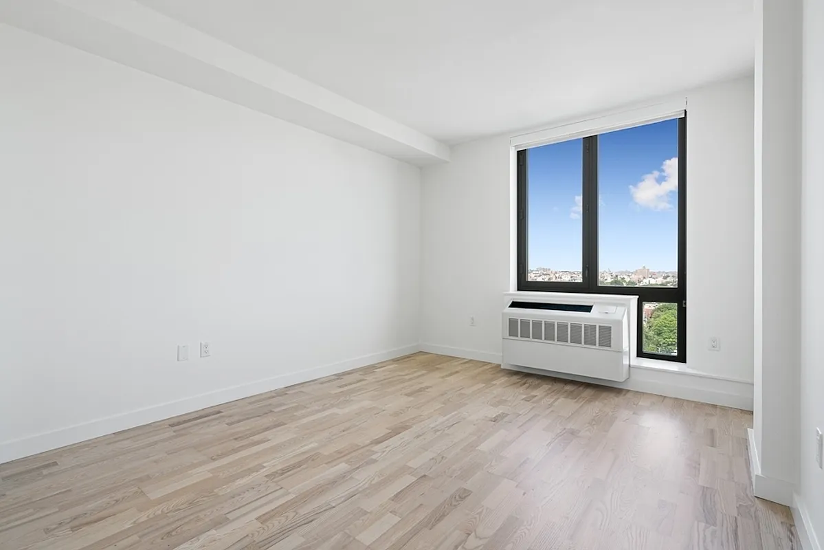 626 Flatbush Avenue, Unit 12D Brooklyn, NY 11225 - Photo 2 of 18 an empty room with wooden floor and a window