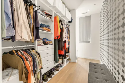 a view of walk in closet with clothes and shoes