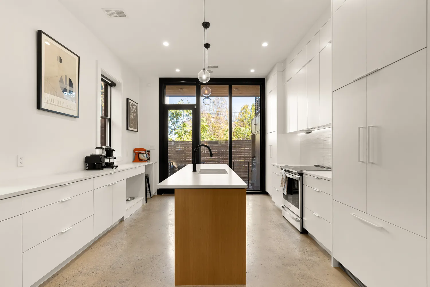 a large kitchen with granite countertop a large counter top a sink stainless steel appliances and cabinets