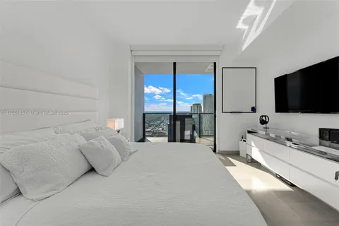 a spacious bedroom with a large bed and a flat screen tv