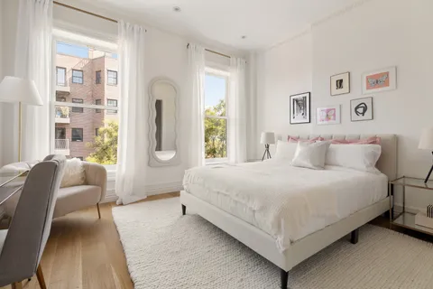 a bedroom with a bed couch and a large window