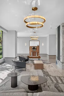 a living room with couches and a chandelier