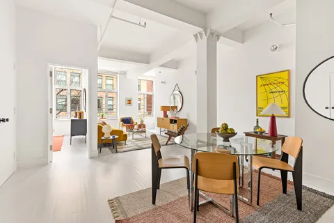 a living room with furniture and a painting on the wall