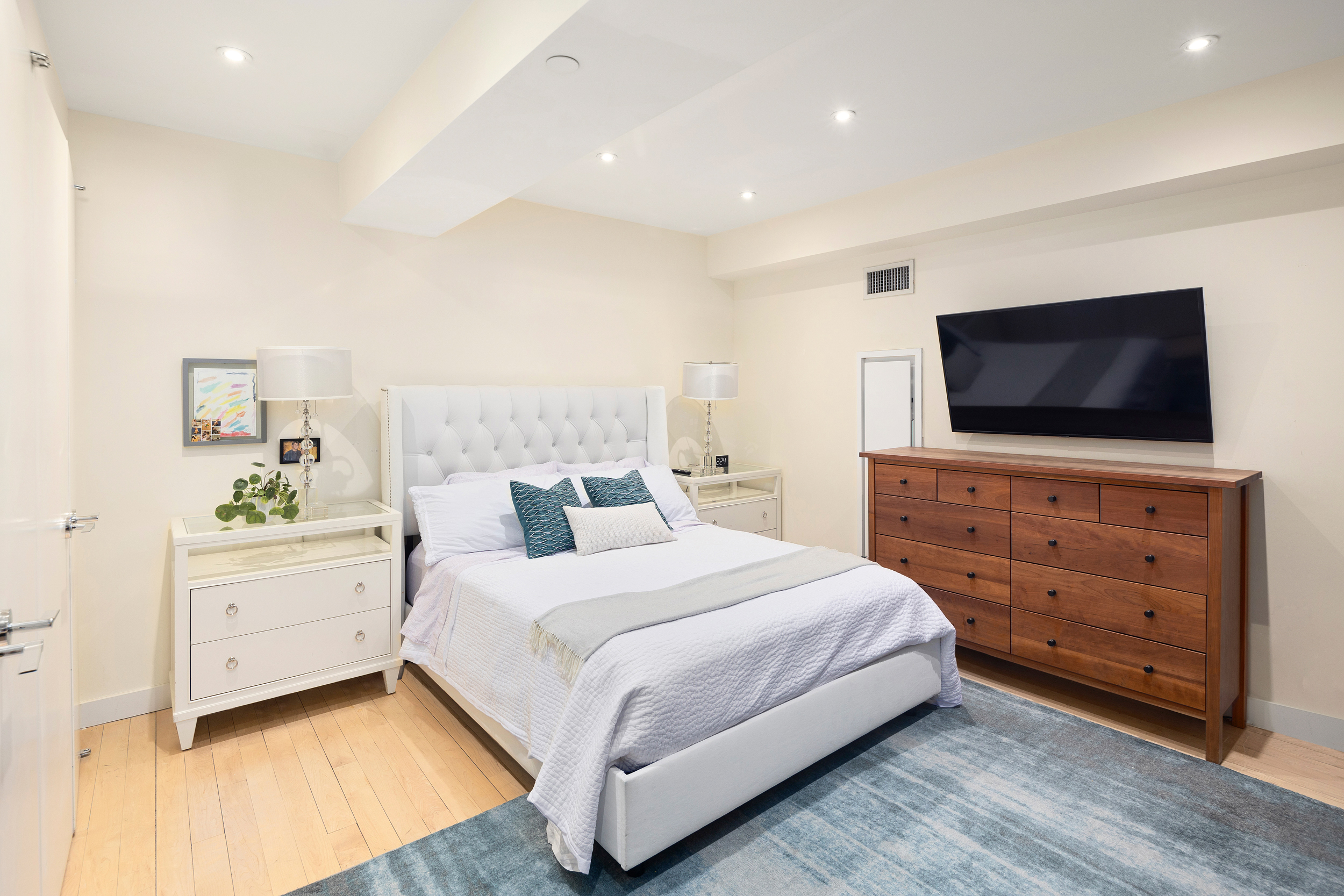 15 Broad Street, Unit 2404 Manhattan, NY 10005 - Photo 5 of 23 a bedroom with a bed and a flat screen tv