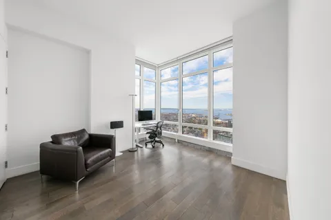 a living room with furniture and a floor to ceiling window