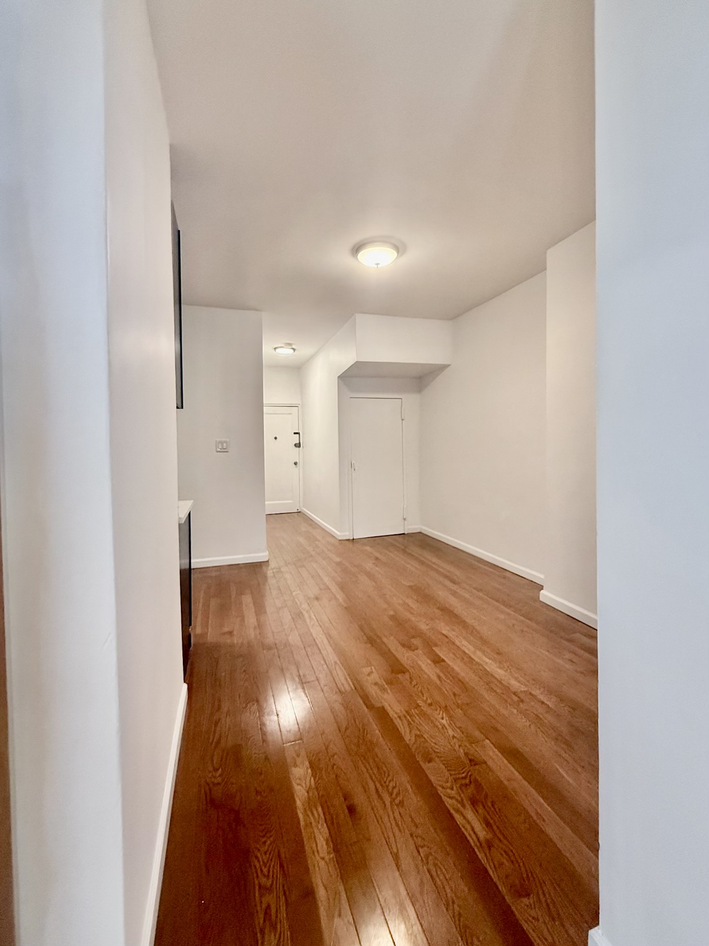 18-48 21st Drive, Unit 1R Queens, NY 11105 - Photo 9 of 11 a view of empty room with wooden floor