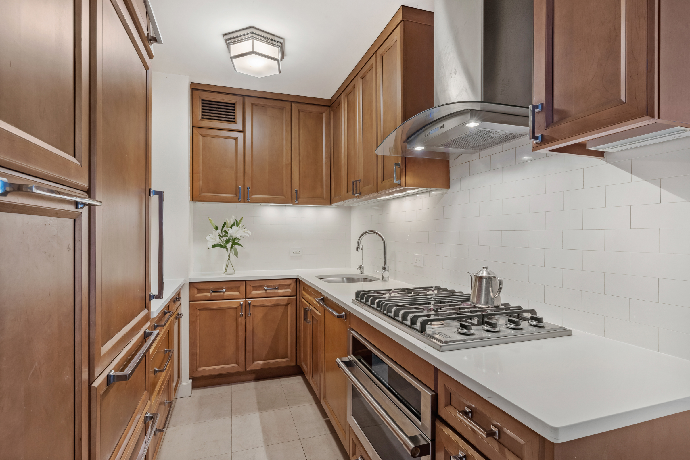61 West 62nd Street, Unit 23G Manhattan, NY 10023 - Photo 3 of 9 a kitchen with stainless steel appliances a sink a stove and a refrigerator