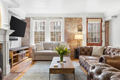 a living room with furniture a flat screen tv and a large window