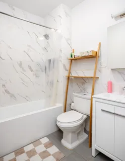 a white toilet sitting next to a bath tub