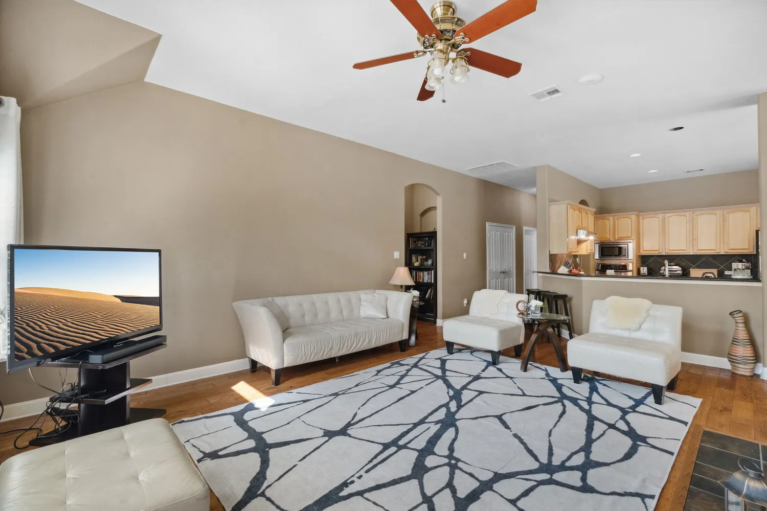 a living room with furniture and a view of kitchen