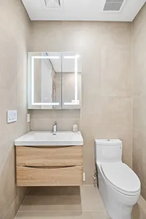 a bathroom with a sink a toilet and mirror