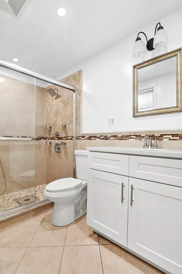 a bathroom with a toilet a sink and mirror