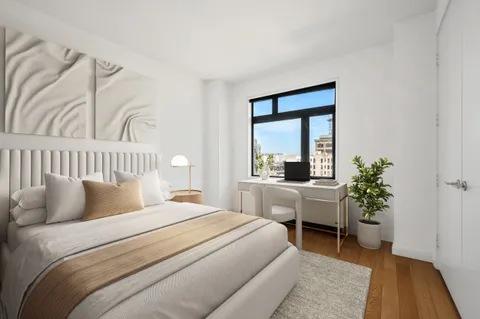 a bedroom with a bed and a potted plant
