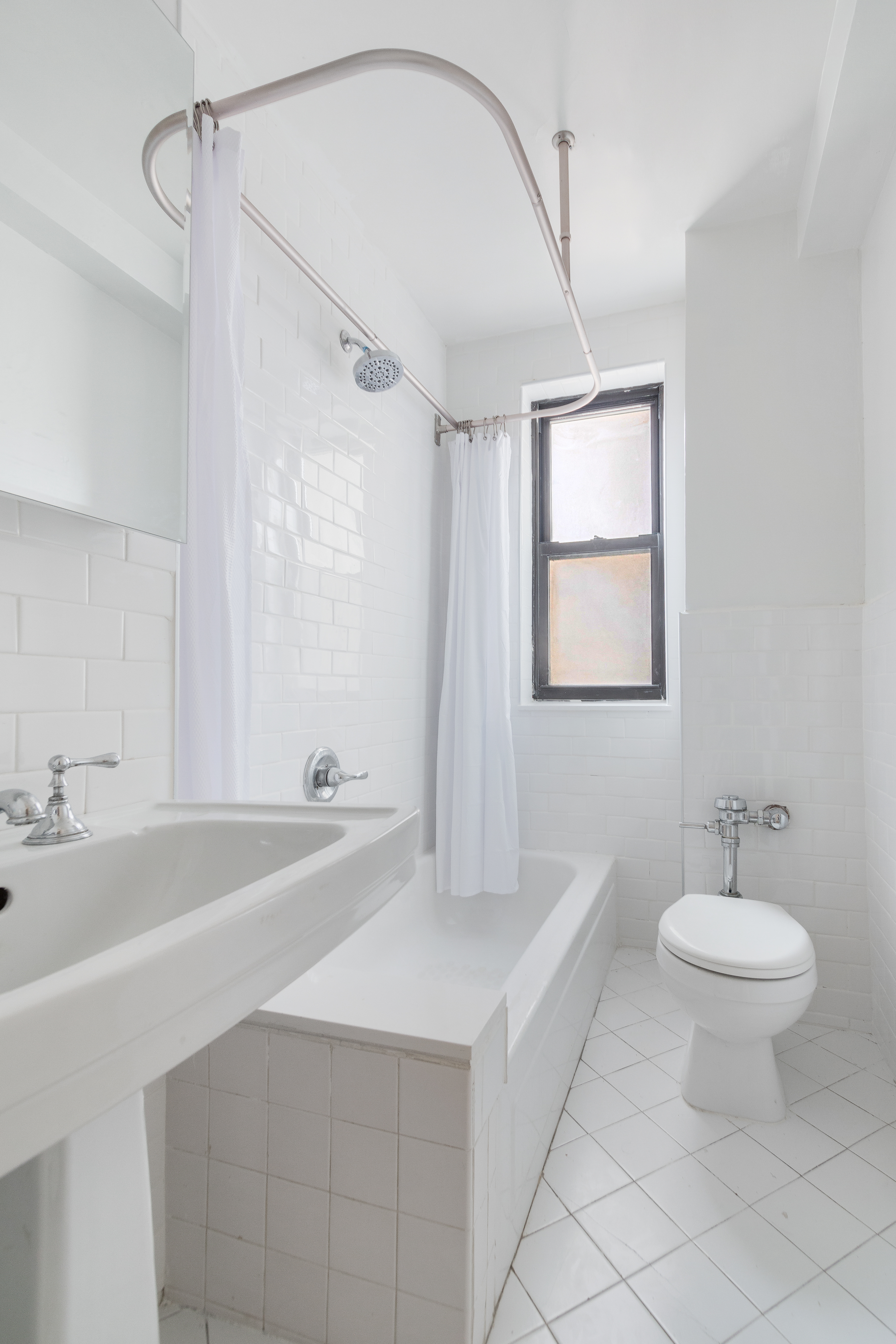 235 West End Avenue, Unit 8G Manhattan, NY 10023 - Photo 10 of 13 a bathroom with a double vanity sink a mirror and a bathtub