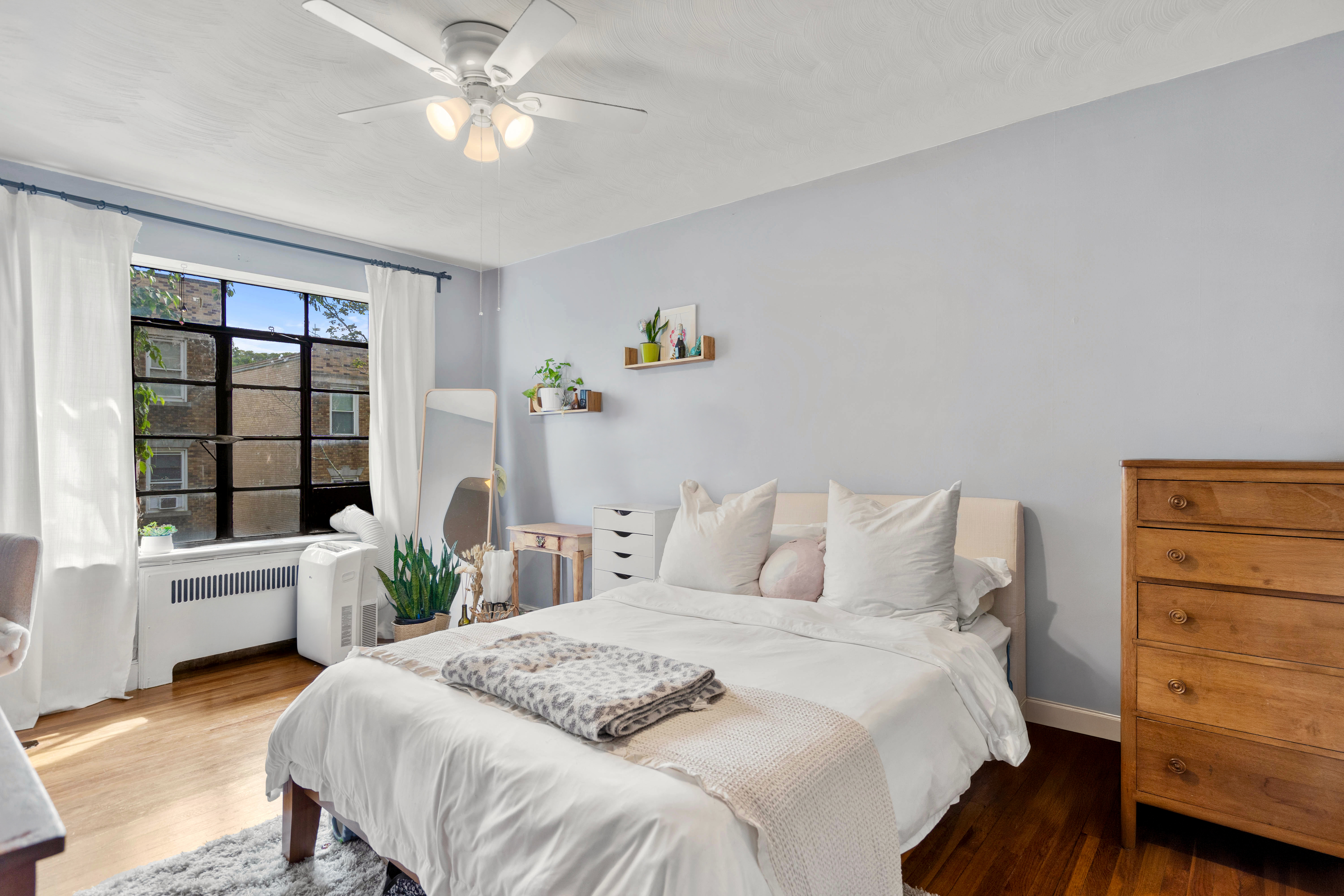 93 Strathmore Road, Unit 8 Brighton, MA 02135 - Photo 5 of 16 a bedroom with a bed and a window with the potted plants