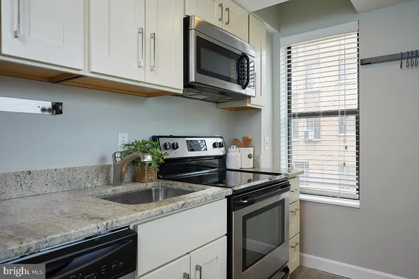 a kitchen with stainless steel appliances granite countertop a sink stove and microwave