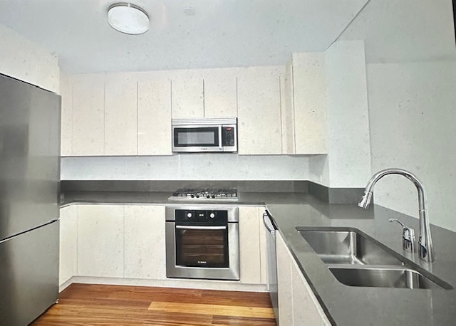 57 Reade Street, Unit 7A Manhattan, NY 10007 - Photo 3 of 5 a kitchen with sink a microwave and stove