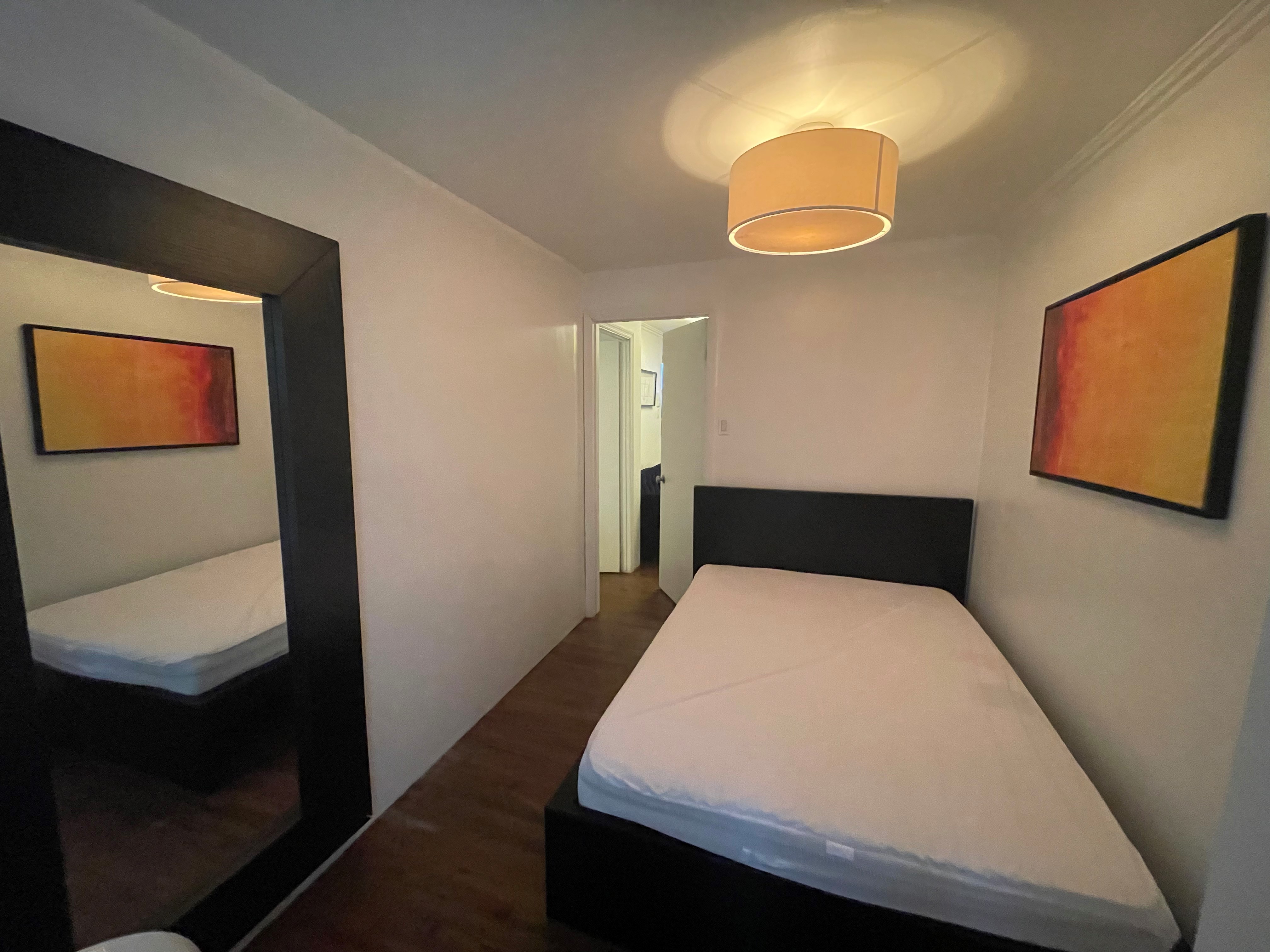 120 East 10th Street, Unit 1 Manhattan, NY 10003 - Photo 19 of 24 a bedroom with a bed and a painting on the wall