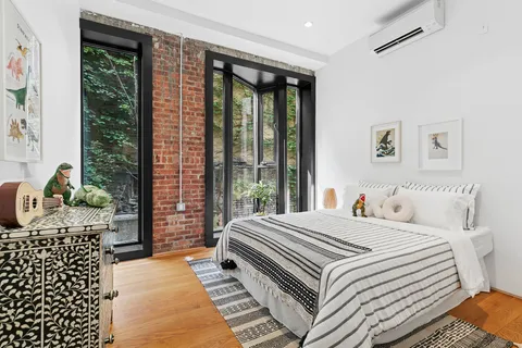 a bedroom with a bed and wooden floor