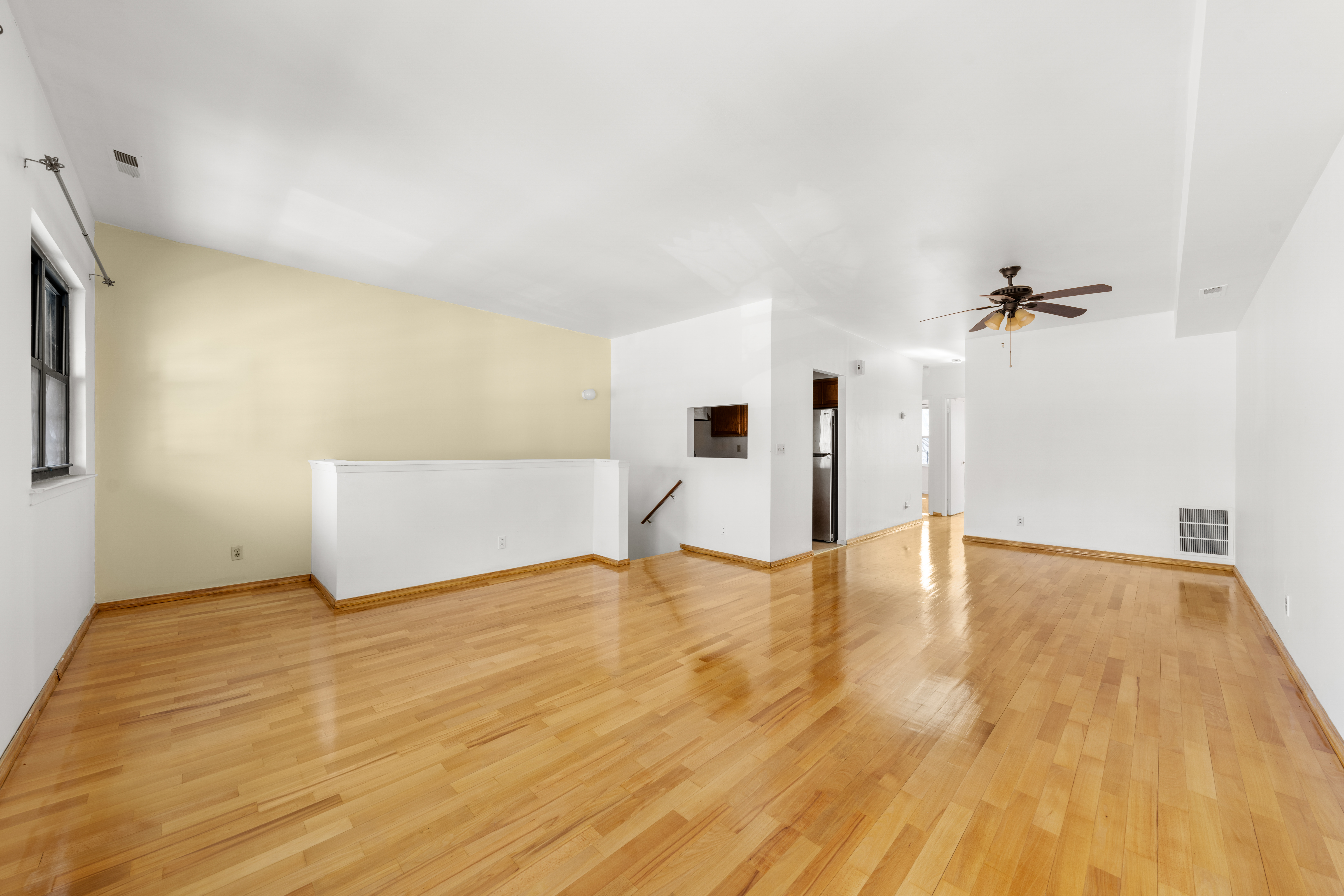 a view of empty room with wooden floor