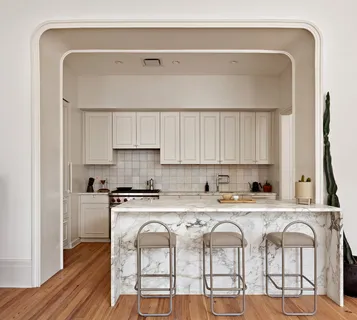 a white kitchen with a stove a sink and a microwave