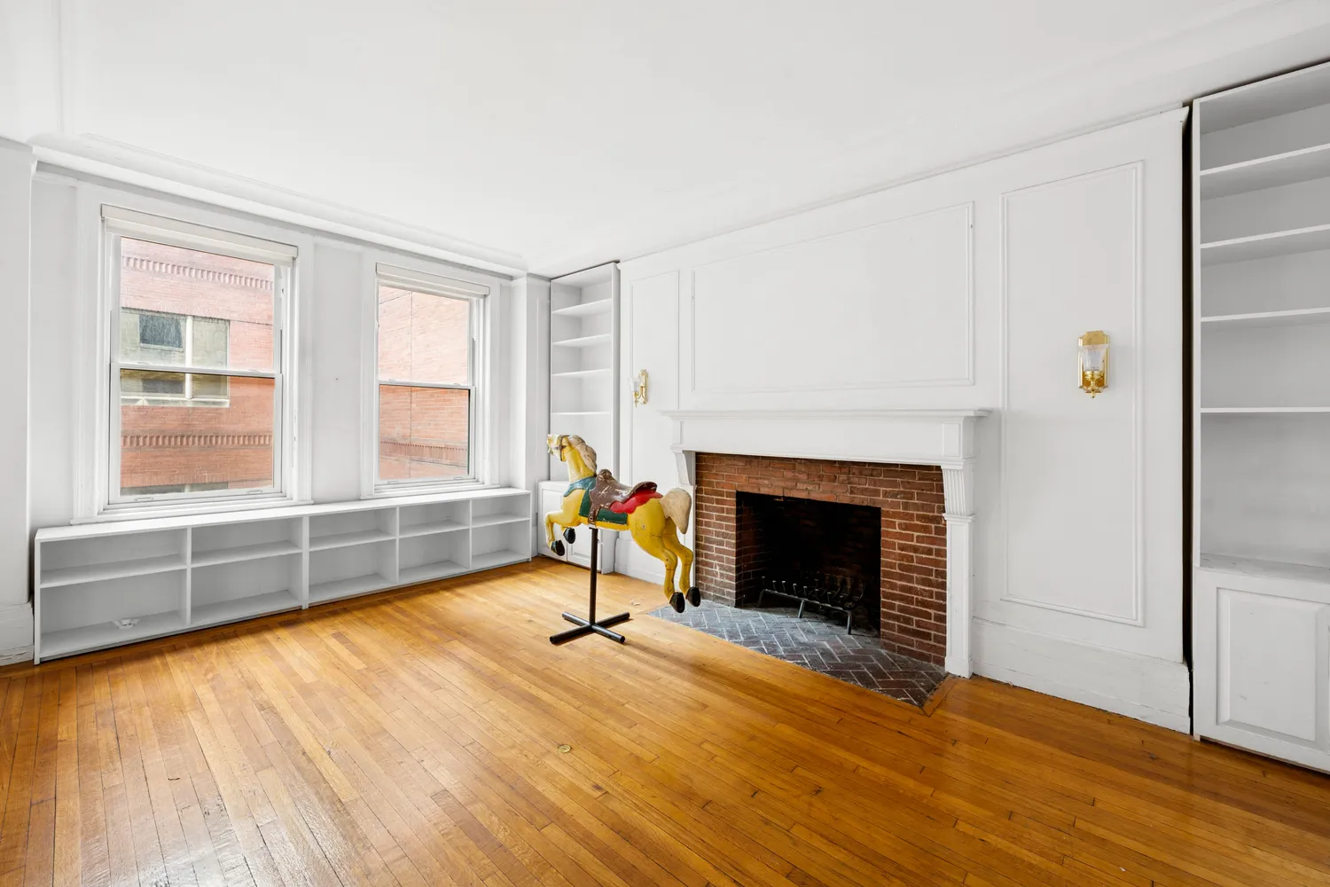 a view of empty room with wooden floor and fireplace
