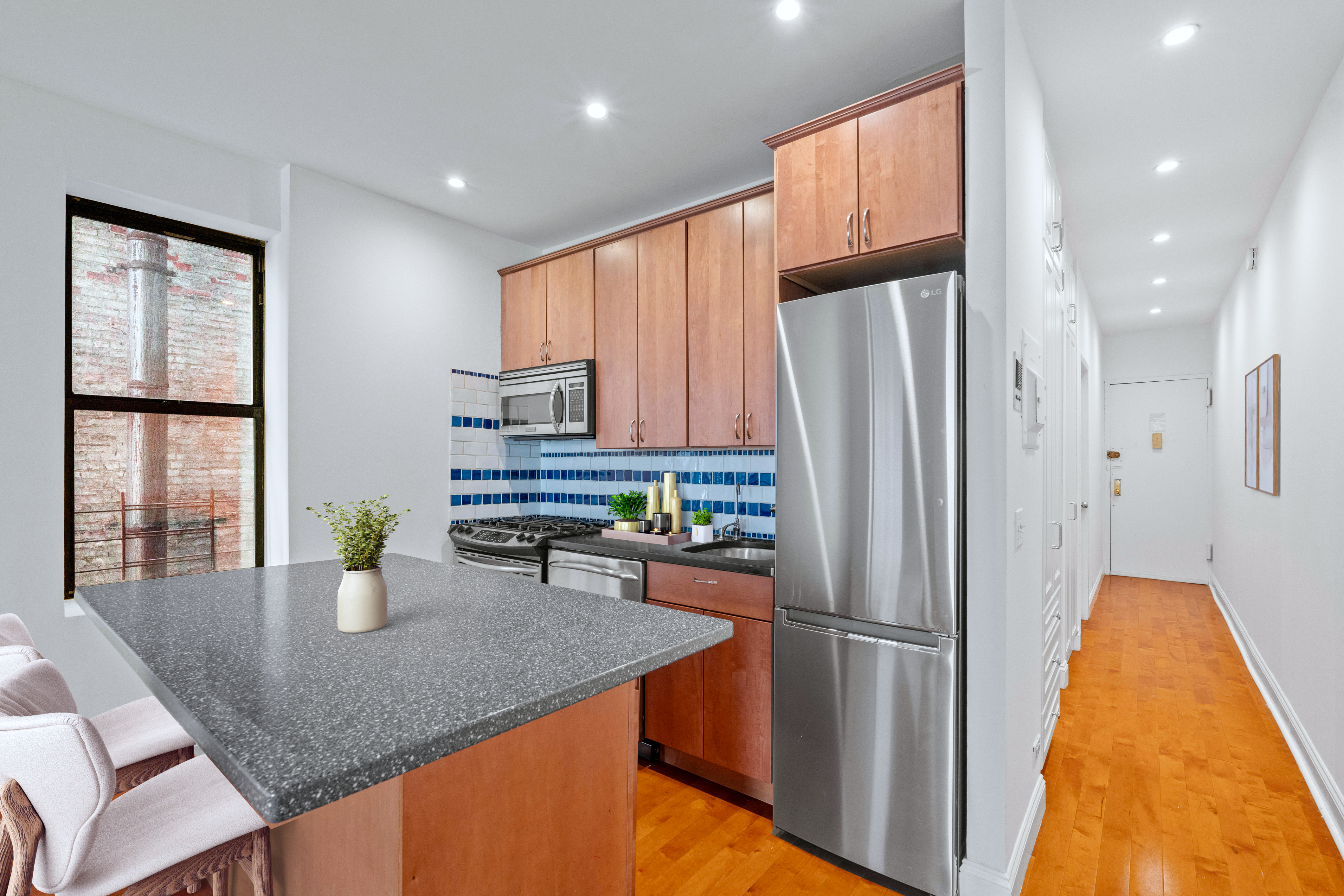 1264 Amsterdam Avenue, Unit 3D Manhattan, NY 10027 - Photo 3 of 16 a kitchen with stainless steel appliances granite countertop a refrigerator a sink a stove and island