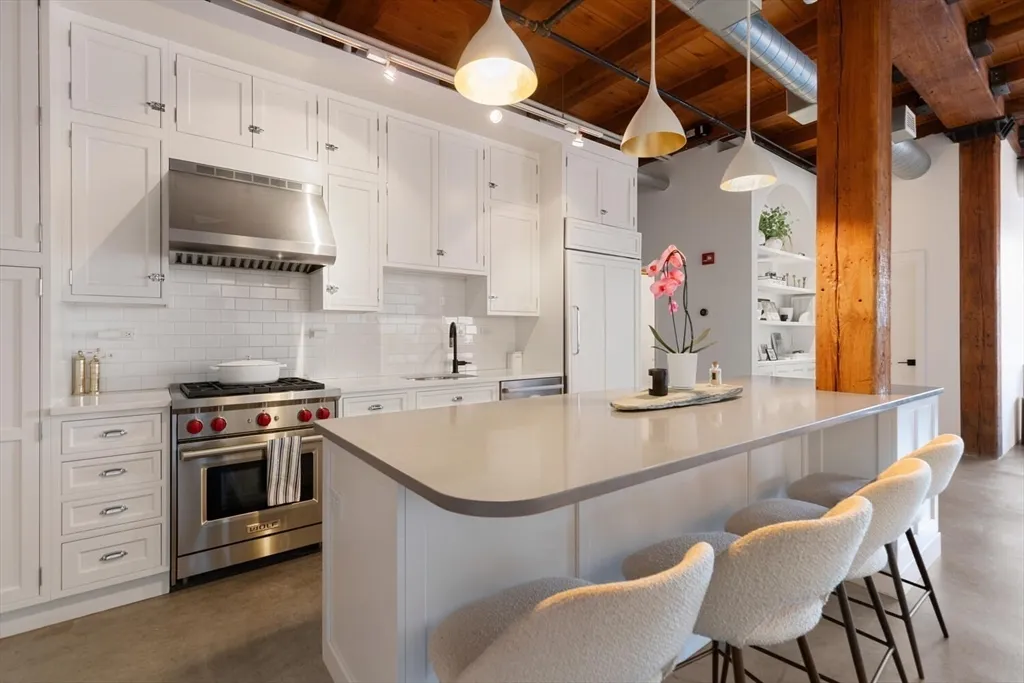 a kitchen with stainless steel appliances granite countertop a sink a stove and a microwave