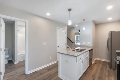 a kitchen with stainless steel appliances granite countertop a refrigerator a sink and a stove