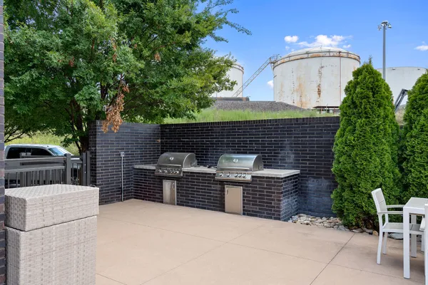 a front view of a house with barbeque oven and seating space