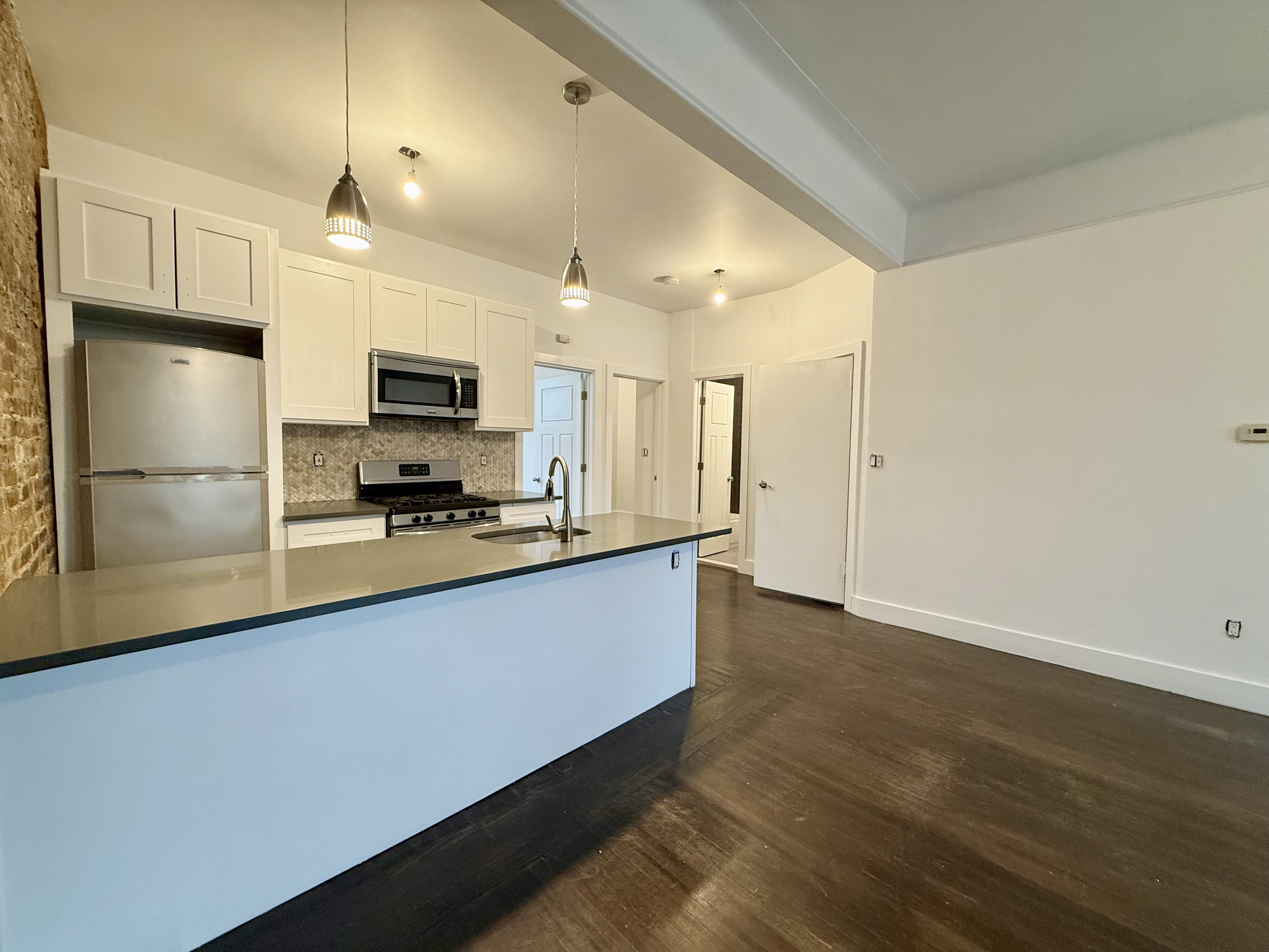 249 94th Street, Unit 1 Brooklyn, NY 11209 - Photo 2 of 13 a large kitchen with stainless steel appliances a large counter top a stove and a refrigerator