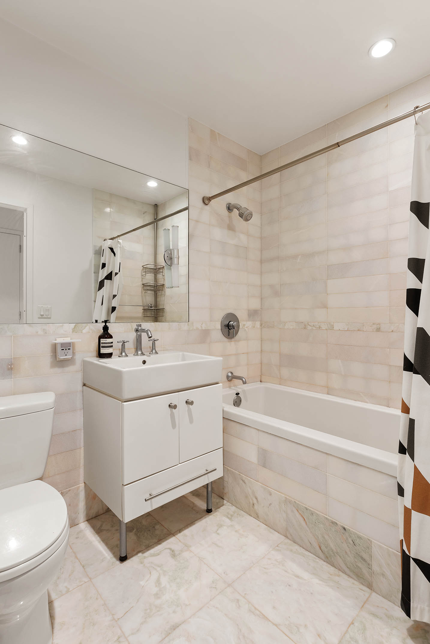 635 West 42nd Street, Unit 7F Manhattan, NY 10036 - Photo 5 of 7 a bathroom with a double vanity sink toilet and shower