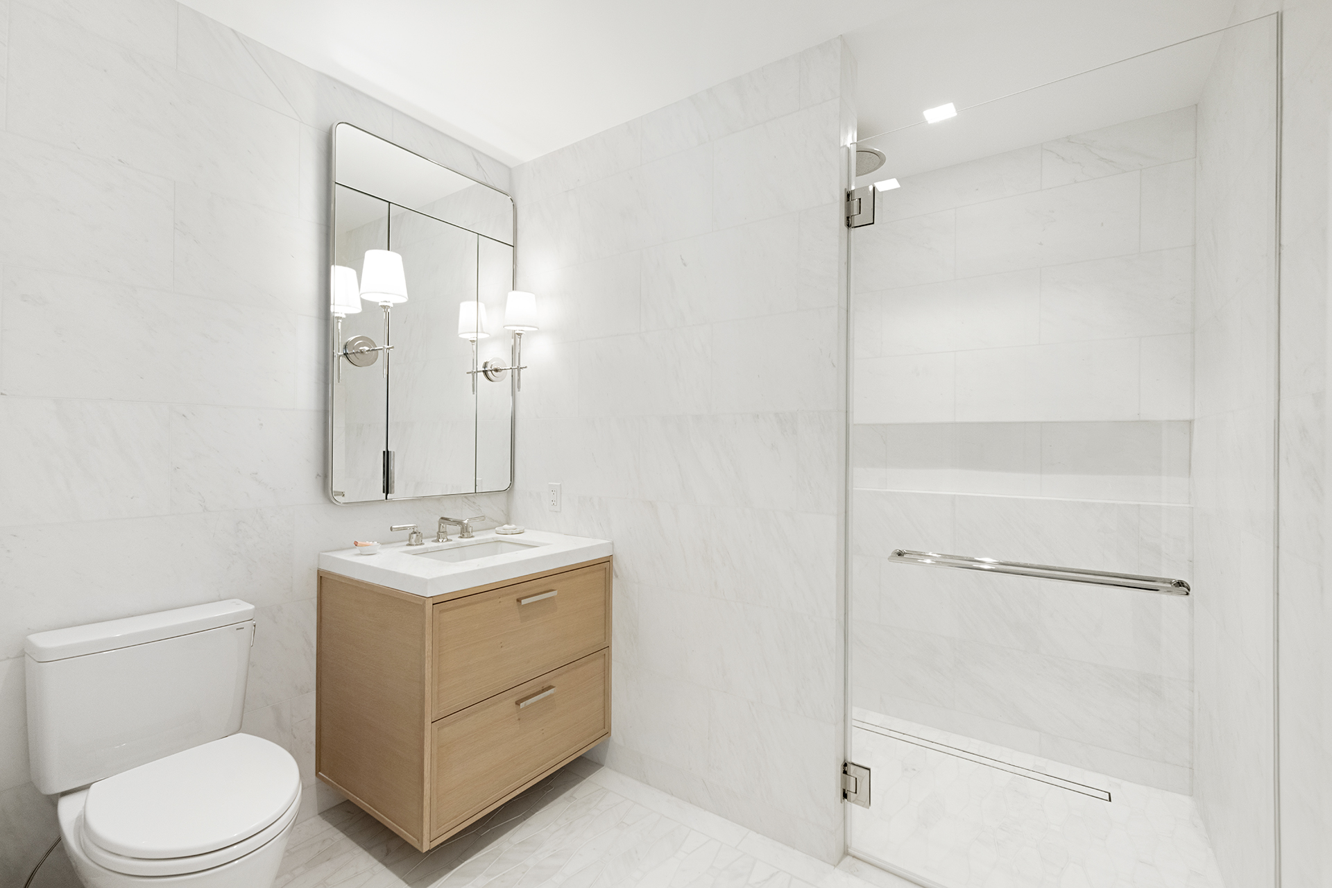 200 East 83rd Street, Unit 4A Manhattan, NY 10028 - Photo 7 of 26 a bathroom with a toilet sink vanity and mirror